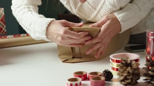Adult Wrapping Christmas Present With Decorative Elements