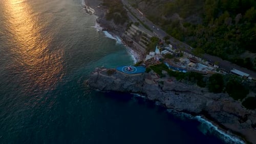 Luftvideo Malerischer Blick auf den Hubschrauber auf dem blauen Hubschrauberlandeplatz in der Nähe der Küste bei Sonnenuntergang