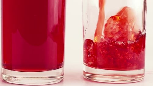 Le
jus de grenade est versé dans des gobelets en verre. Ralenti.