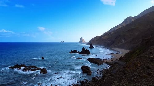 Rocky coast of the Atlantic Ocean with a narrow line of sandy beach.