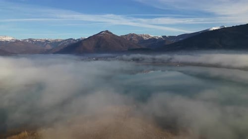 A Drone Flies Over a Mountain Lake Covered in Thick Morning Fog