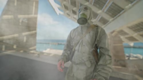 Figure in Hazmat Suit Walking Through Urban Ruins