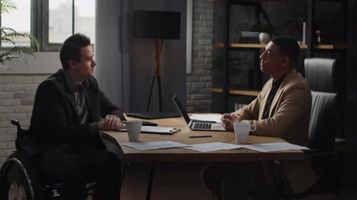 Two Men are Sitting at a Table in an Office and Shaking Hands Businessmen Shake Hands After Signing