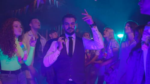 Partygoers Celebrate and Dance Under Neon Lights