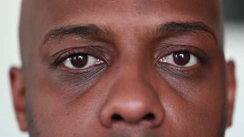 Tired Black African man close-up eyes looking at camera closing eyes