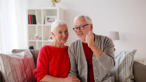 Affectionate Senior Couple Smiling and Giving Thumbs Up