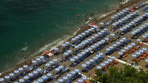 Contemplando una escena de playa veraniega con hermosas aguas cristalinas, gente jugando en la arena y