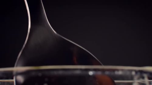 Liquid Dripping from Silver Spoon in Close Up