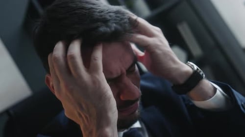 Stressed Businessman Holding Head in Office Close Up