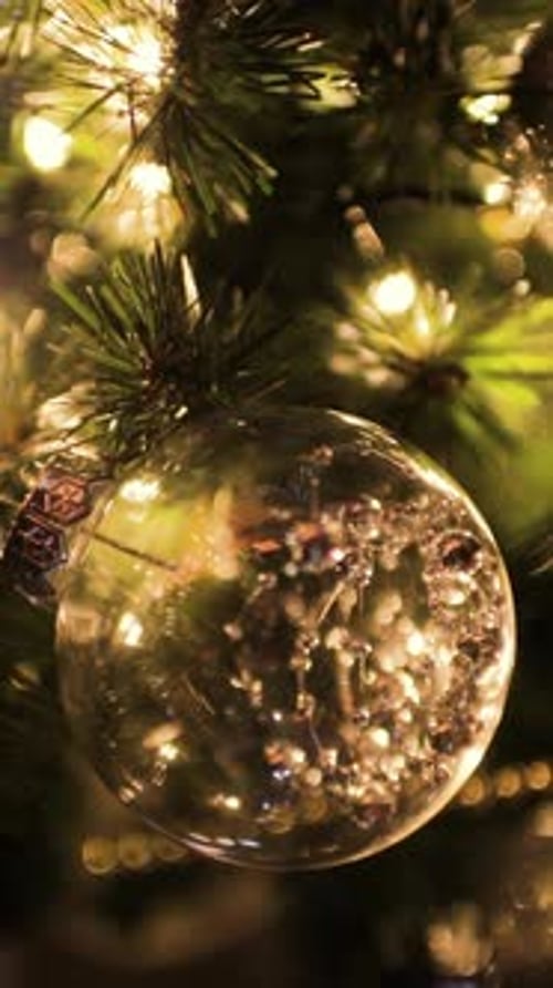 Christmas Toy on a Christmas Tree Against a Garland in the Blur Vertical Video