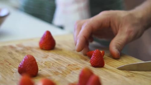 Cutting Fresh Strawberries on Wooden Cutting Board