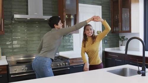 Two Women Dancing Together in a Modern Kitchen