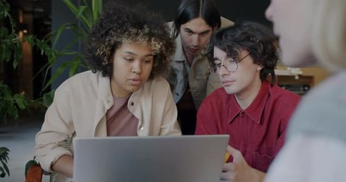 Team Collaborating on Laptop in Modern Office
