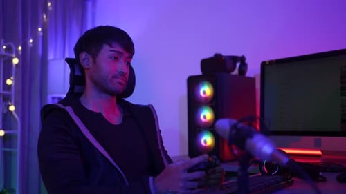 Ein Mann spielt in seinem Zimmer ein Computerspiel.