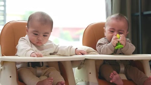 Asian Twin Babies Sitting on Safety Chair the Chair Can Use for Car Seats