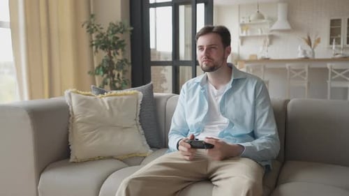 Young Man Enjoying Video Game at Home on Couch