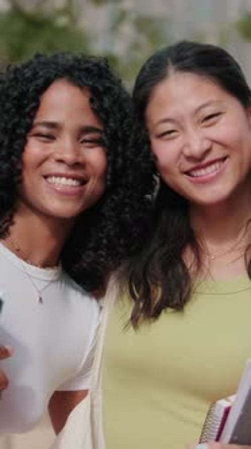 Estudantes asiáticas e afro-americanas com cadernos e livros