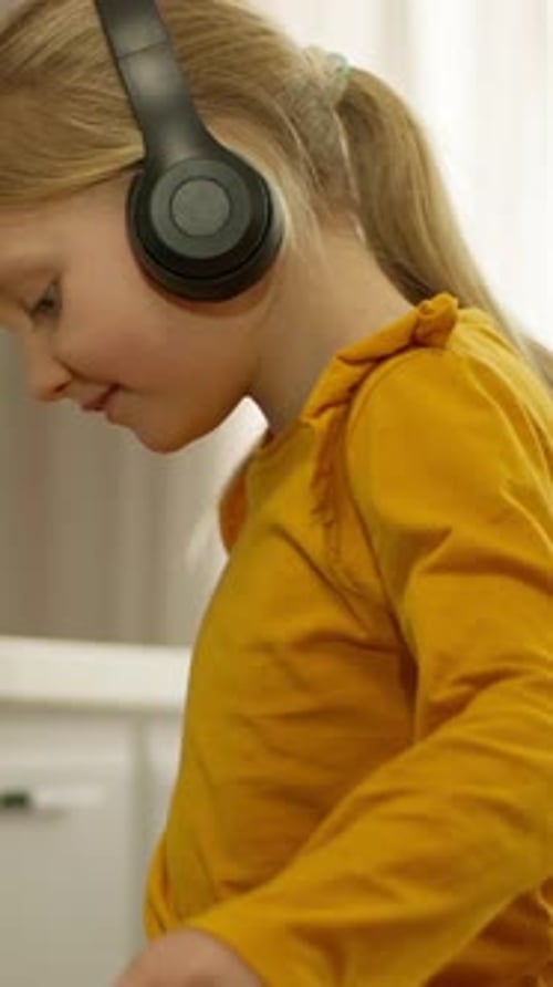 Caucasian Little Girl Child Kid Daughter in Headphones Listen Music Songs Dancing Listen Melody