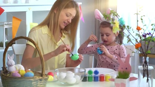 Mother and Daughter Painting Easter Eggs Together at Home