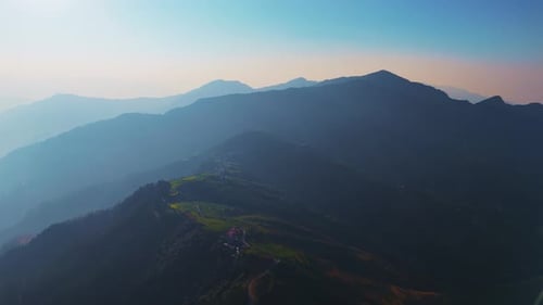 aerial shot of misty mountain peaks fading into the distance
