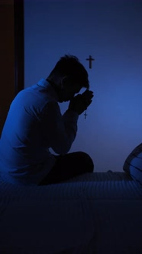 Man Praying in Bedroom with Rosary and Cross