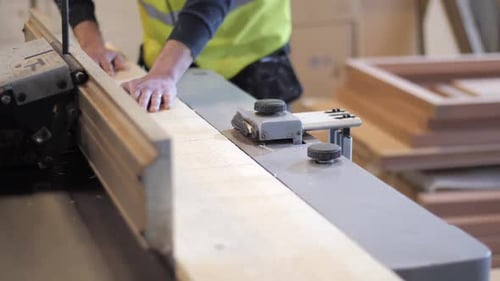 Woodworker processing timber in a wooden workshop.