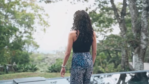 Attractive female enjoys majestic terrace surrounded by green nature, handheld view