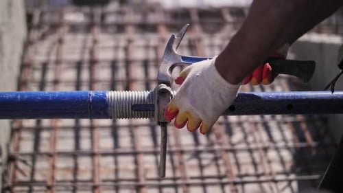 A Worker Twists a Telescopic Rack for Monolithic Formwork