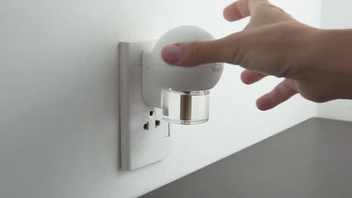 Plugging in Air Freshener into Electrical Outlet