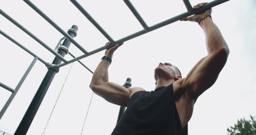 Un gars sportif fait de l'exercice et entraîne les muscles des bras et du tronc au terrain de sport
