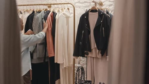 Young Black Woman Choosing Clothes in Stylish Showroom
