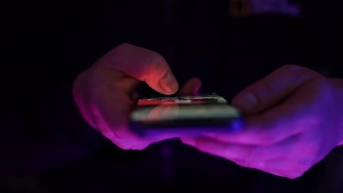 Close-up of hands front view using smartphone and scrolling on mobile screen.