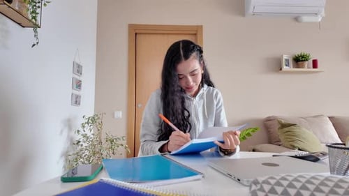 Young Woman Studying at Home, Taking Notes