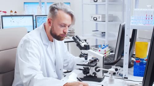 Scientist Analyzing Sample with Microscope in Laboratory