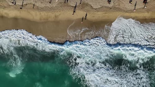 Vertical View From the Drone to the Beach Where People are Relaxing and Enjoying a Walk on the Beach