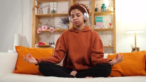 Woman Meditates in Lotus Position at Home