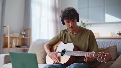 Skilful Musician Playing Guitar in Domestic Place Closeup Man Touching Strings