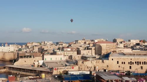 Hot air balloon passing over Acre old city port houses and Mosque at sunrise, Aerial view