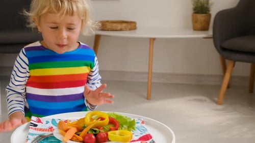 Blonde Child Considers Vegetables in Bright Home Setting