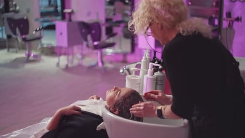Hairstylist Washing Client's Hair at Salon Sink