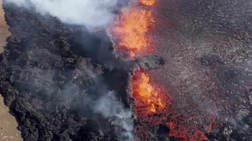 Magma spewing from fissure volcano eruption in Iceland, sunny day, aerial