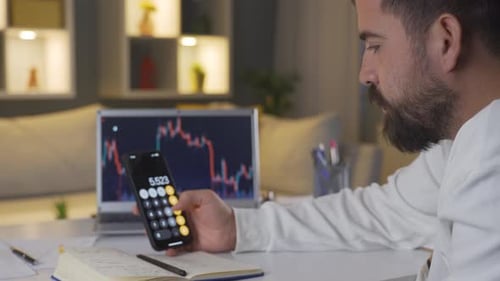 The man calculating on the phone. He's taking notes.