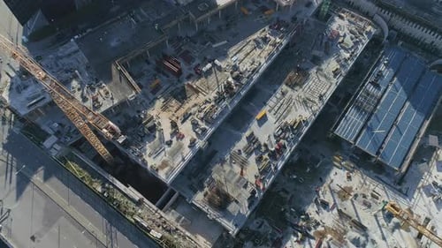 Drohnenaufnahmen aus der Luft von oben nach unten von einem Industriebauhof, der gerade Häuser baut.