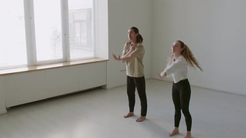Dance Partners Doing Arm Circles during Warmup in Studio