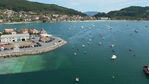 Boats Floating In The Blue Sea Near The Port In Aldan, Spain. - aerial pullback