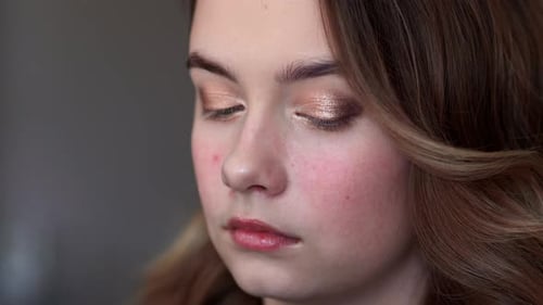 Visagistin malt Augenlider auf ein Model-Mädchen