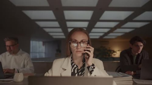 Business Lady Speaking on Phone and Working on Laptop Late in Office