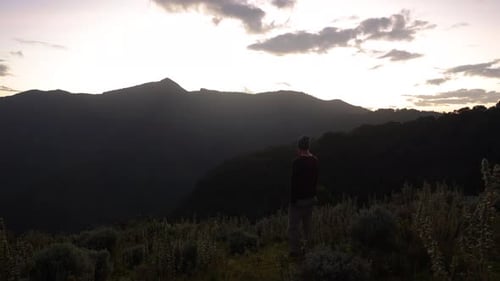 Person Standing on Hilltop at Sunrise