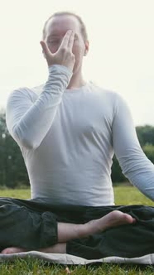 Group of Sportsmen Performs Breathing Exercise Outdoors in a Green