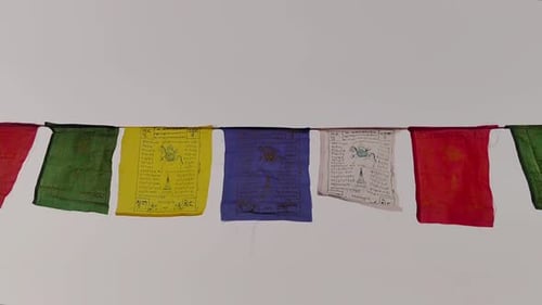 Colorful Tibetan prayer flags fluttering in breeze against blue sky